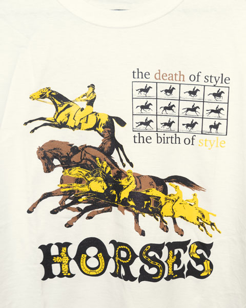 an offwhite t-shirt showing in detail the graphic printed on it. The graphic is printed in yellow, brown and black. it shows a group of horses in a flying gallop with a Muybridge sequence above that. Printed around this frame are the words the death of style the birth of style. Below everything written in a western font is the word horses