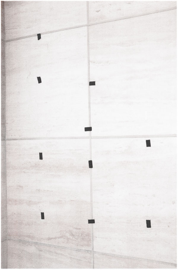 a marble wall with pieces of black tape affixed