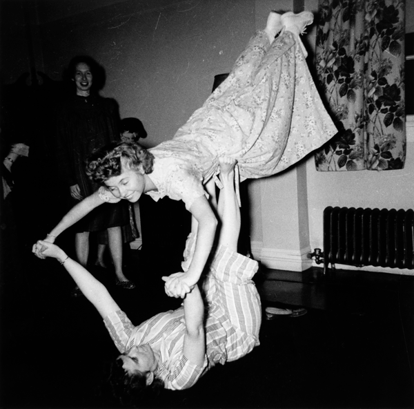 a woman holds another aloft with her hands and feet