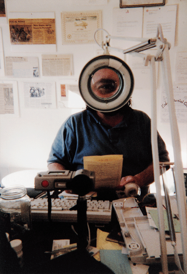 someone looks through a desk magnifying glass
